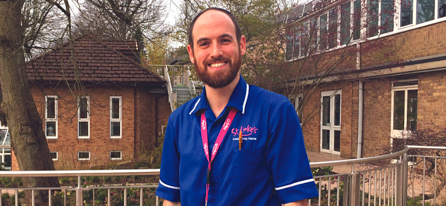 A portrait shot of David Jones from our Community team. He is in the St Luke's gardens and is wearing his uniform. He smiles to the camera.